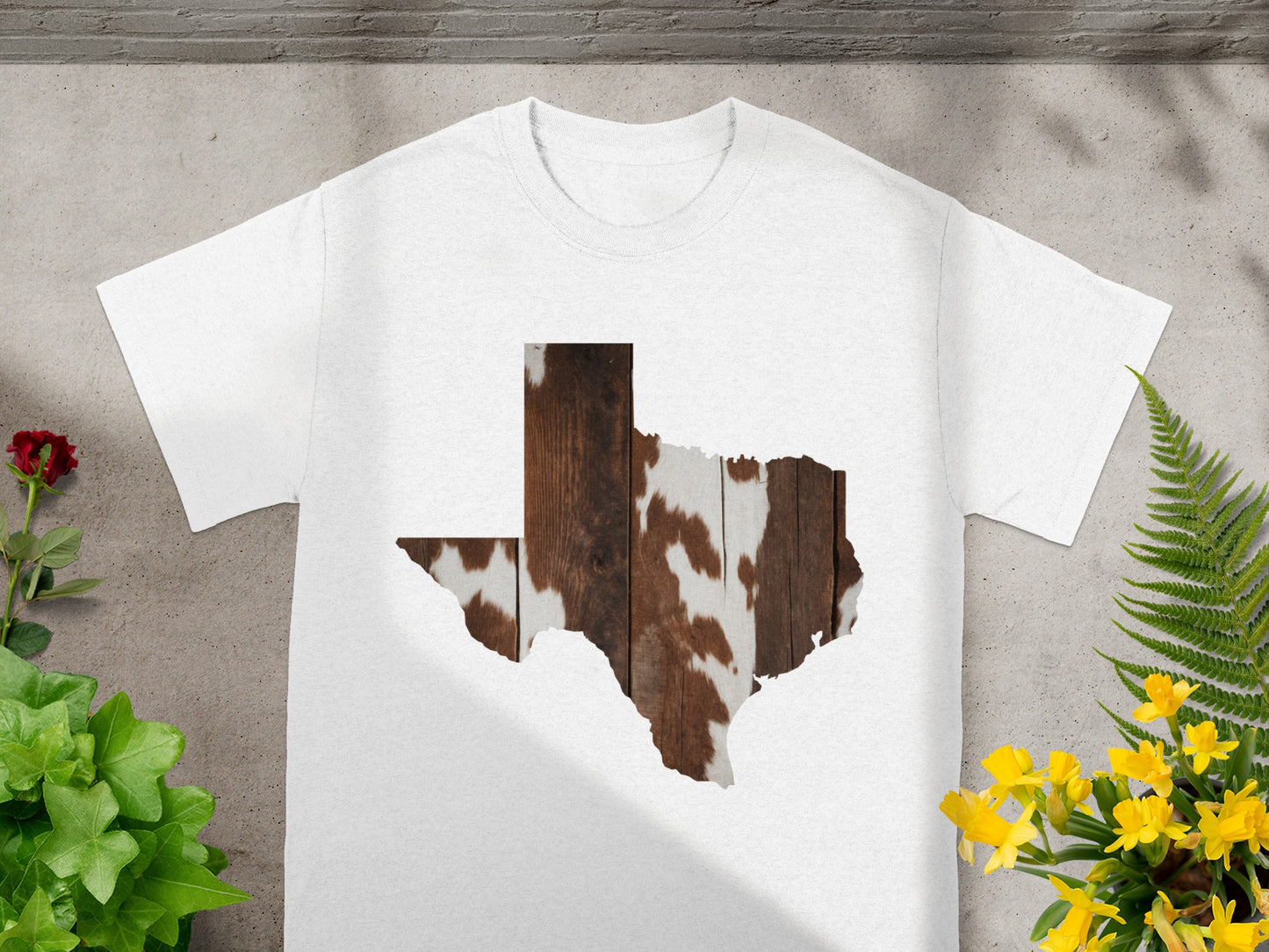 White t-shirt with Texas outline filled with wood and cow print.