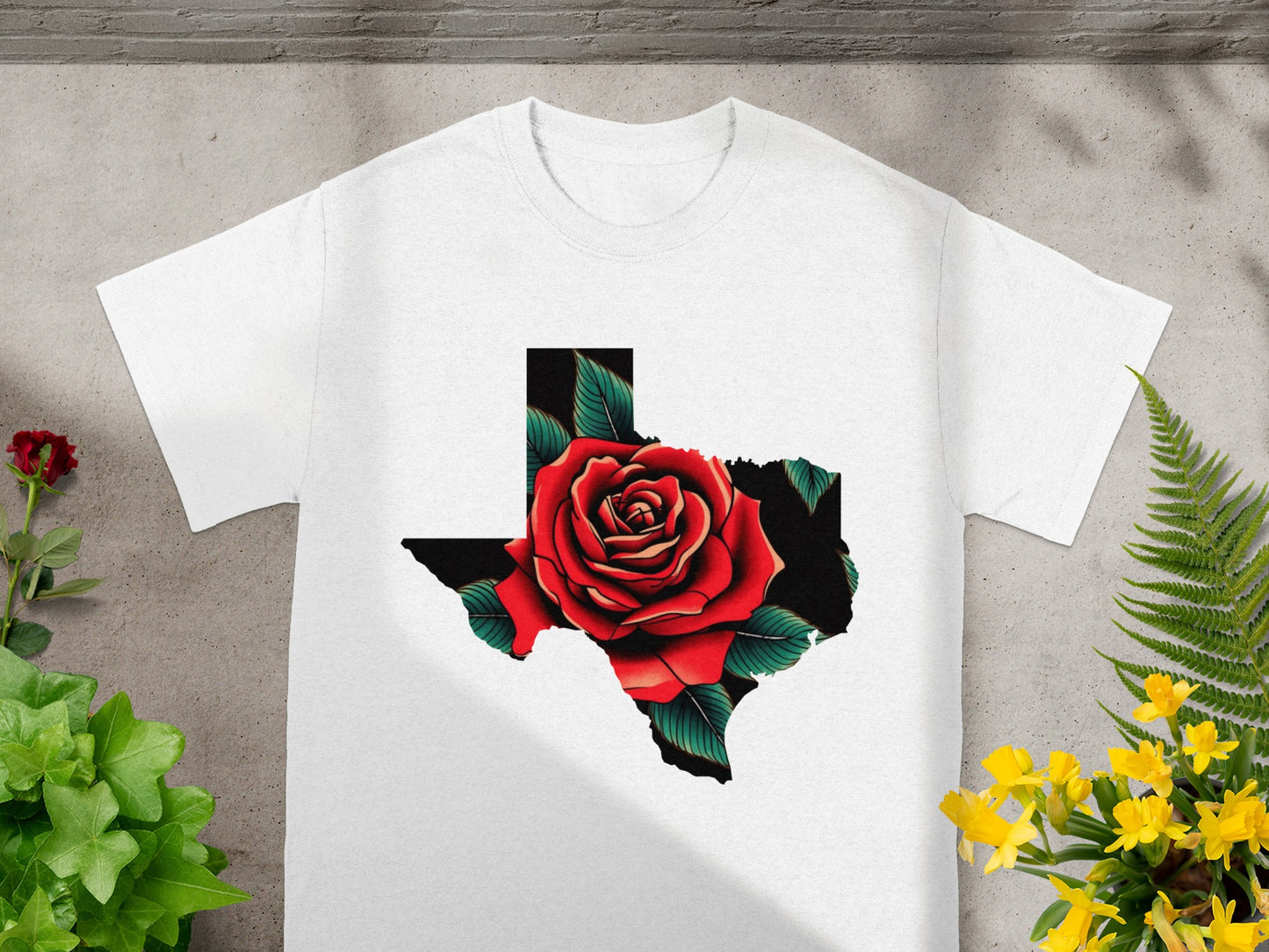 White t-shirt with a Texas outline filled with a red rose and green leaves.