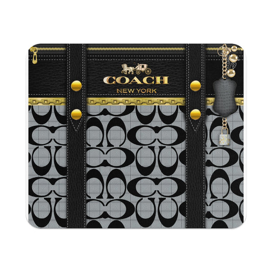 Coach New York pattern with black leather straps, gold zipper, and keyring with lock charm.