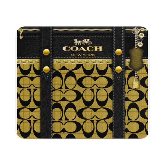 Coach New York logo with black leather straps, gold chain, and charm on monogrammed background.