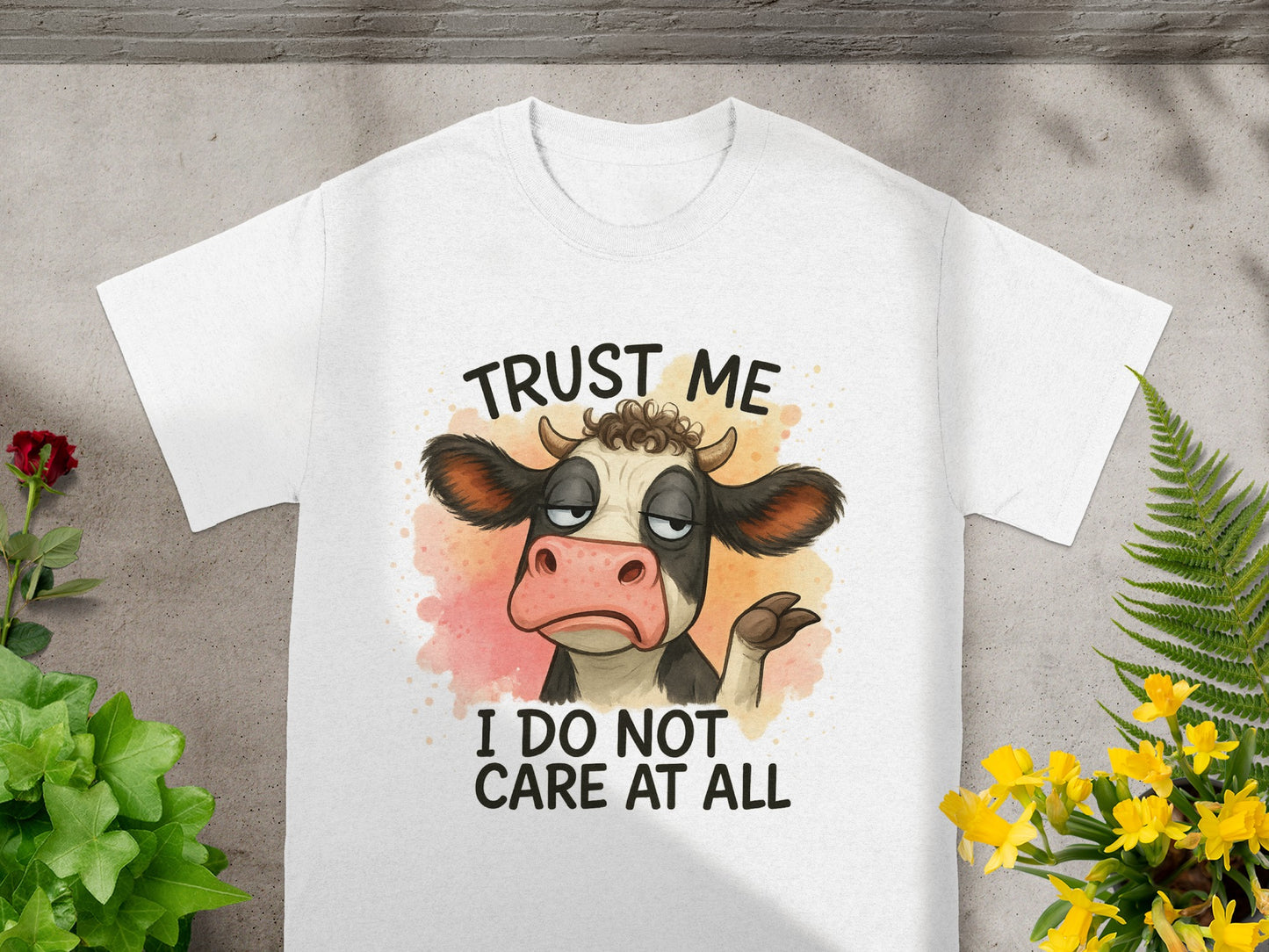White t-shirt with cartoon cow saying "Trust me I do not care at all."