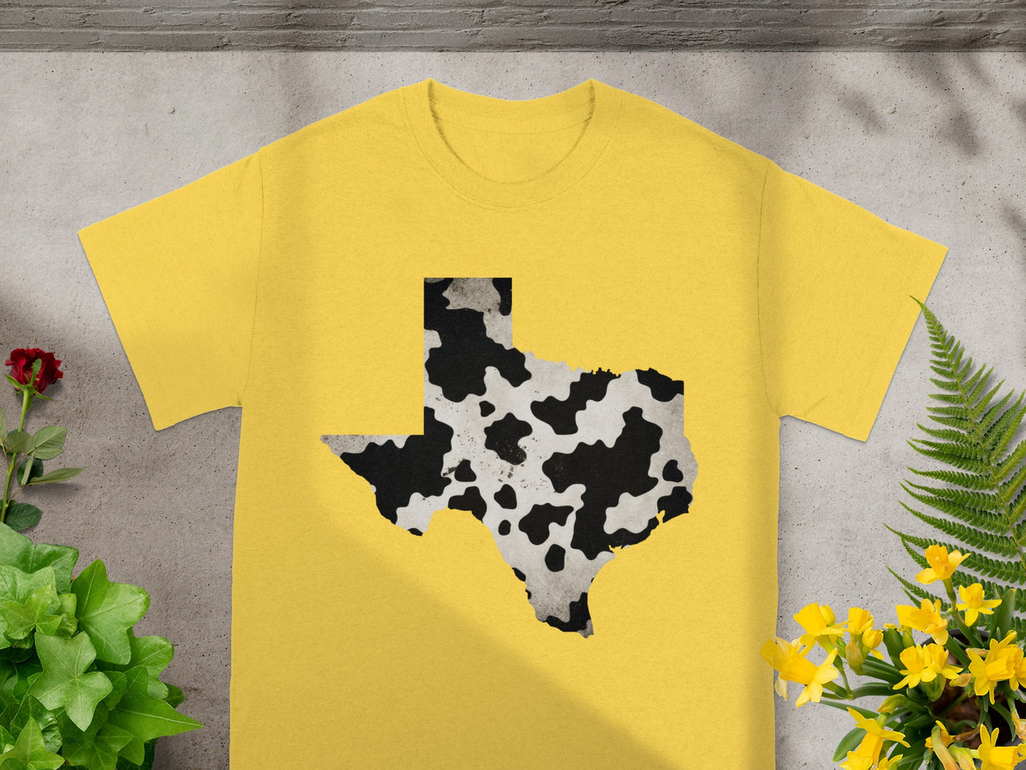Yellow t-shirt with a black and white cow print Texas outline on the front.