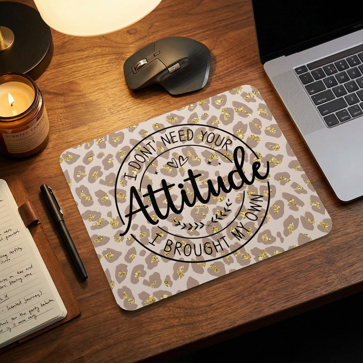 Rectangular mousepad with a gold glitter leopard print and the black text I DONT NEED YOUR ATTITUDE I BROUGHT MY OWN on a wooden desk.