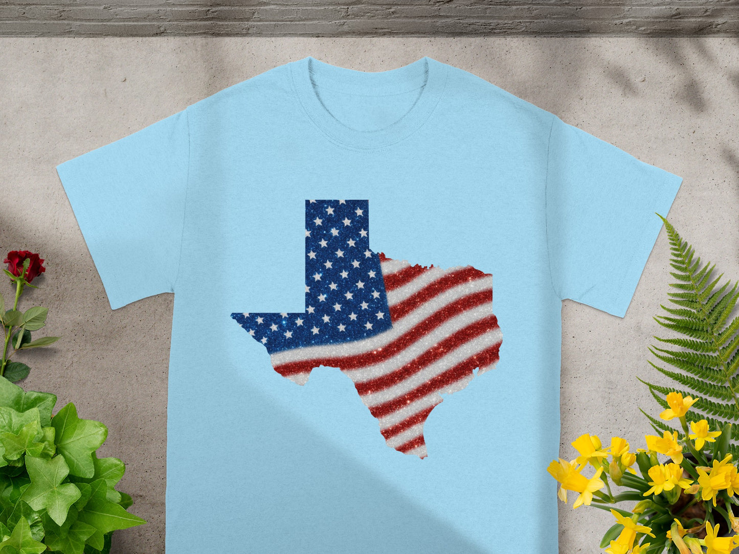 Light blue t-shirt with Texas outline filled with American flag pattern glitter.