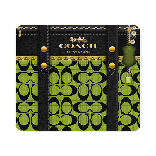 Coach monogram print wallet with gold hardware and green alligator charm.