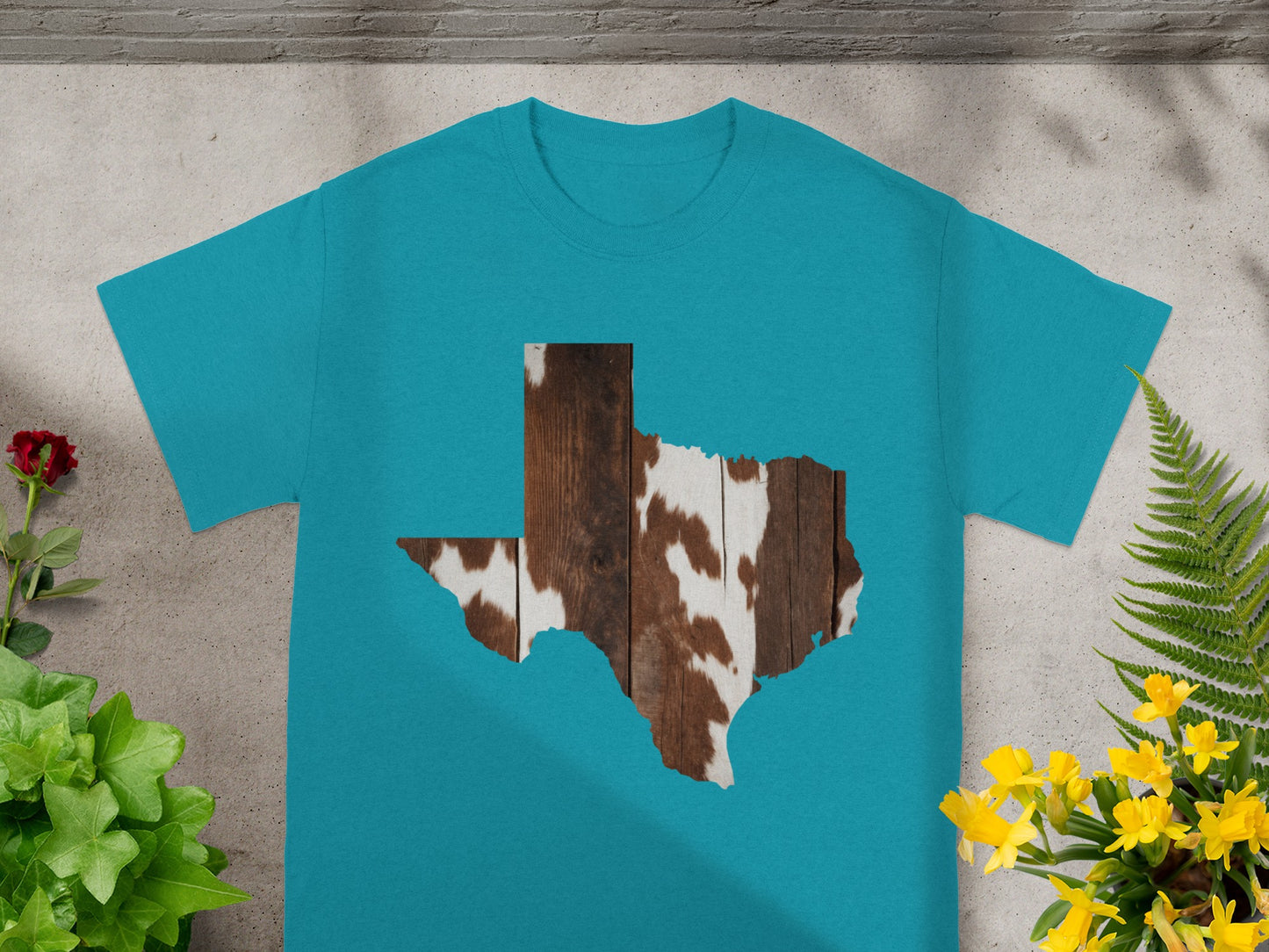 Teal t-shirt with Texas shape filled with cowhide and wood pattern.