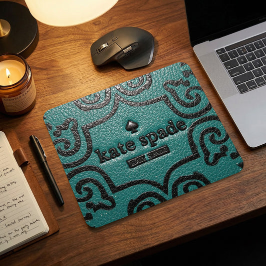 Kate Spade mousepad with black spade logo and embossed pattern.