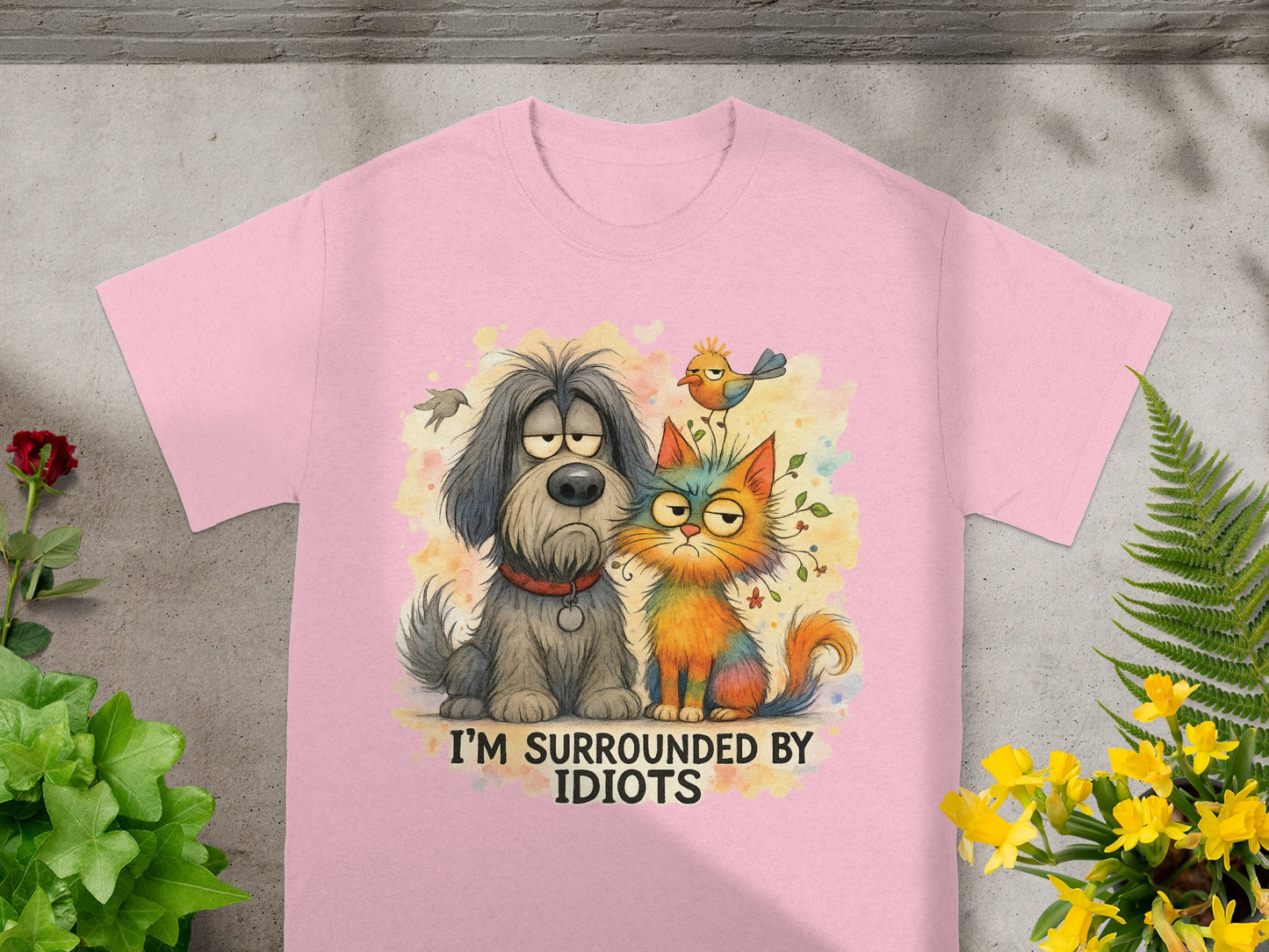 Pink t-shirt with cartoon dog and cat saying "I'M SURROUNDED BY IDIOTS".