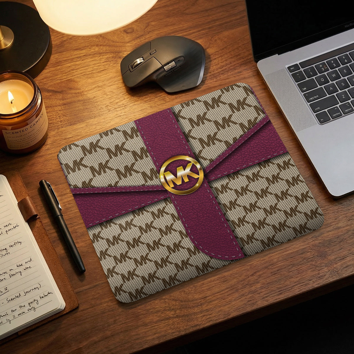 Michael Kors MK logo mousepad with burgundy ribbon detail on desk.