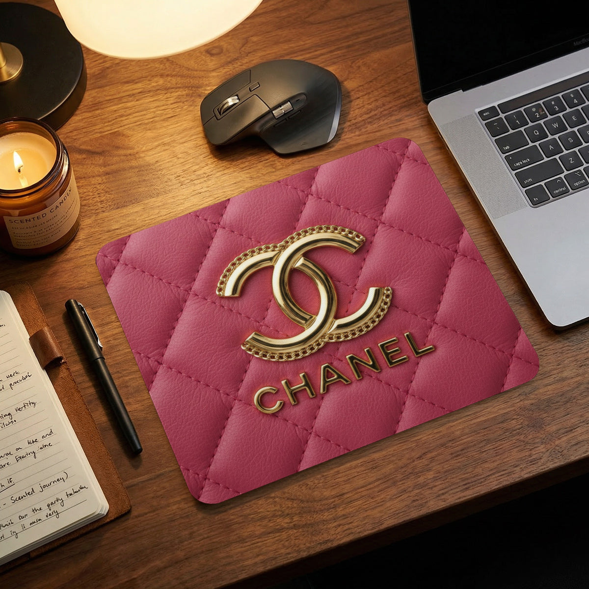Pink quilted mousepad with gold interlocking CC logo and CHANEL text.
