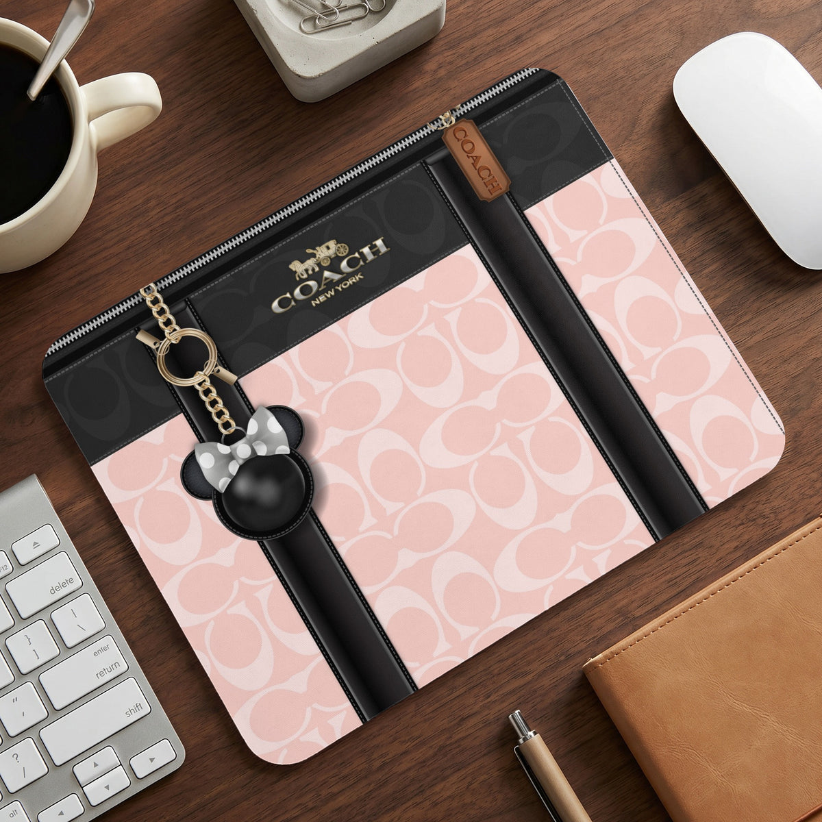Coach pink and black monogram wristlet with Minnie Mouse charm and gold hardware.