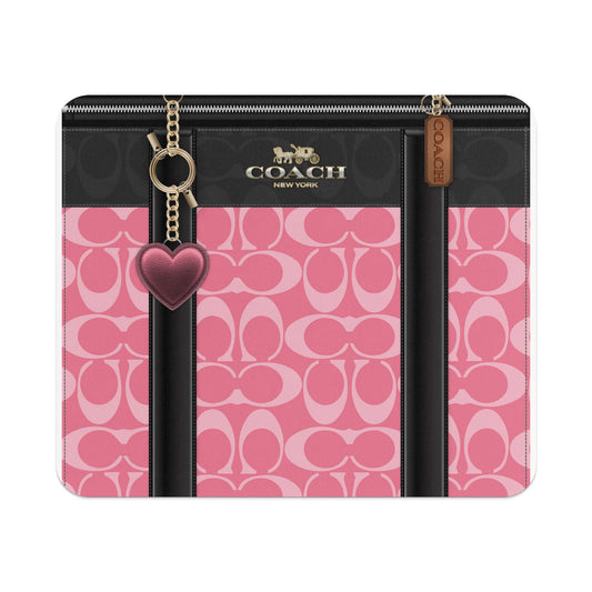 Coach monogram pink pattern wallet with heart charm and leather trim.