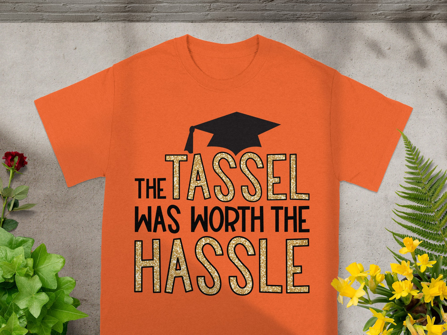 Orange t-shirt with graduation cap and "The tassel was worth the hassle" text.