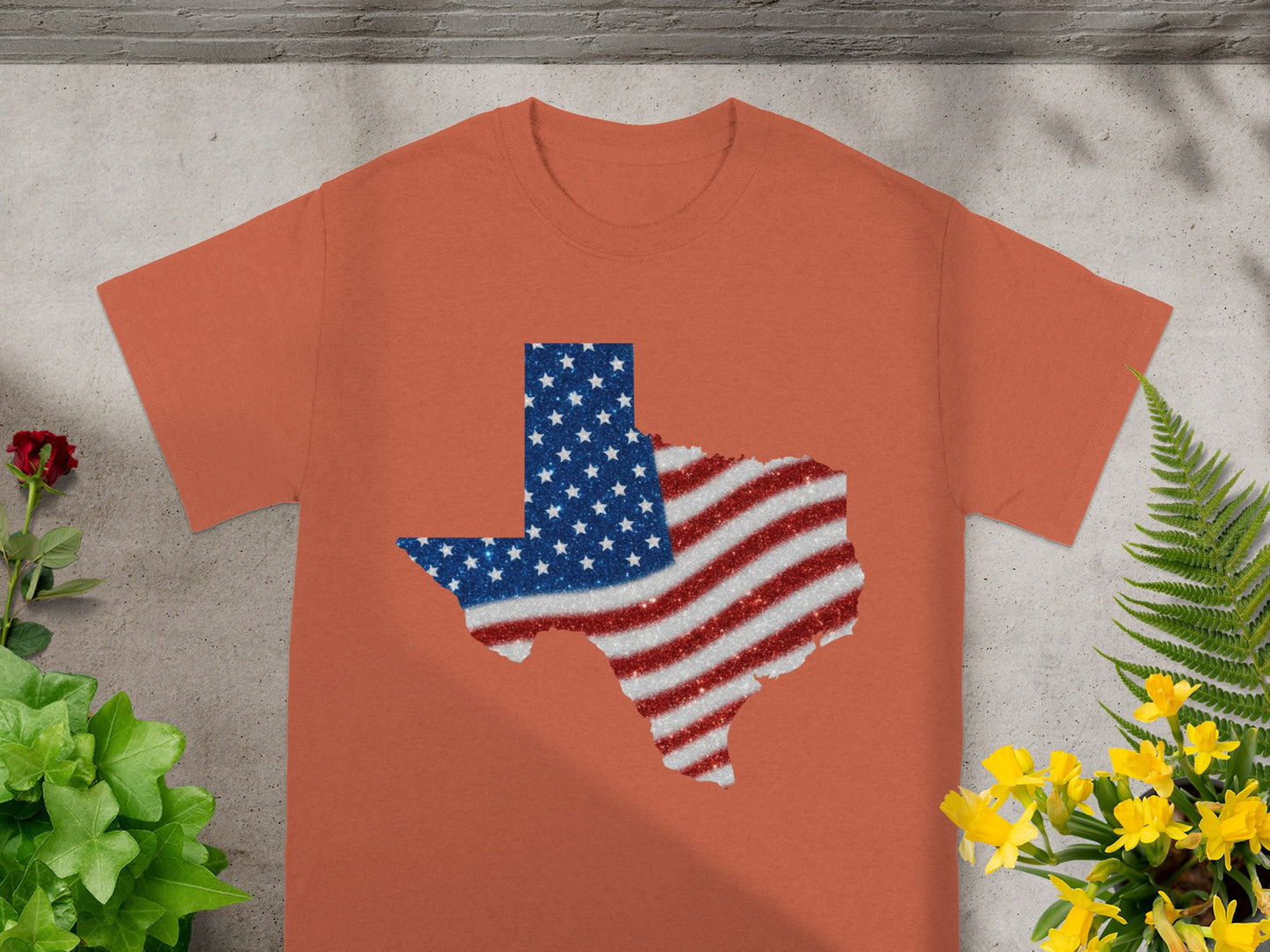 Texas-shaped graphic with American flag design on an orange t-shirt.