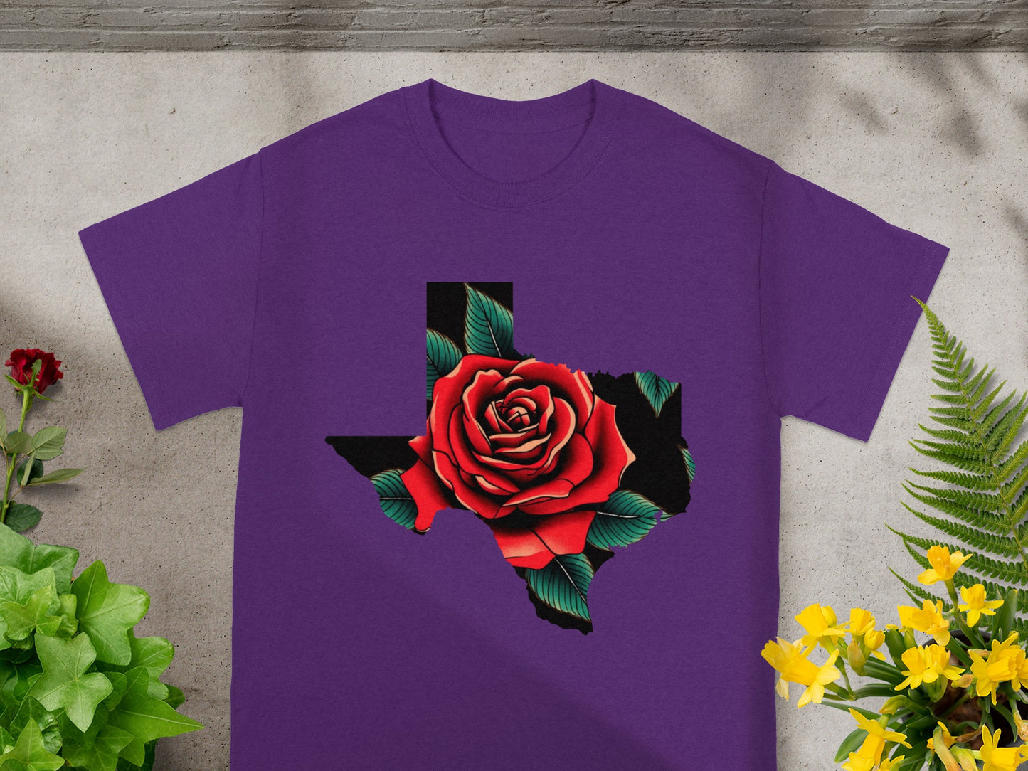 Purple t-shirt with Texas outline filled with a red rose and green leaves.