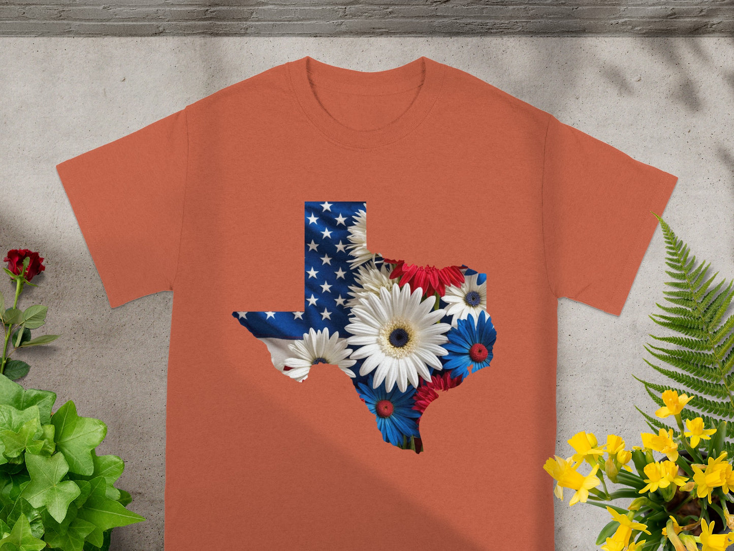 Orange t-shirt with Texas map graphic featuring American flag and flowers.