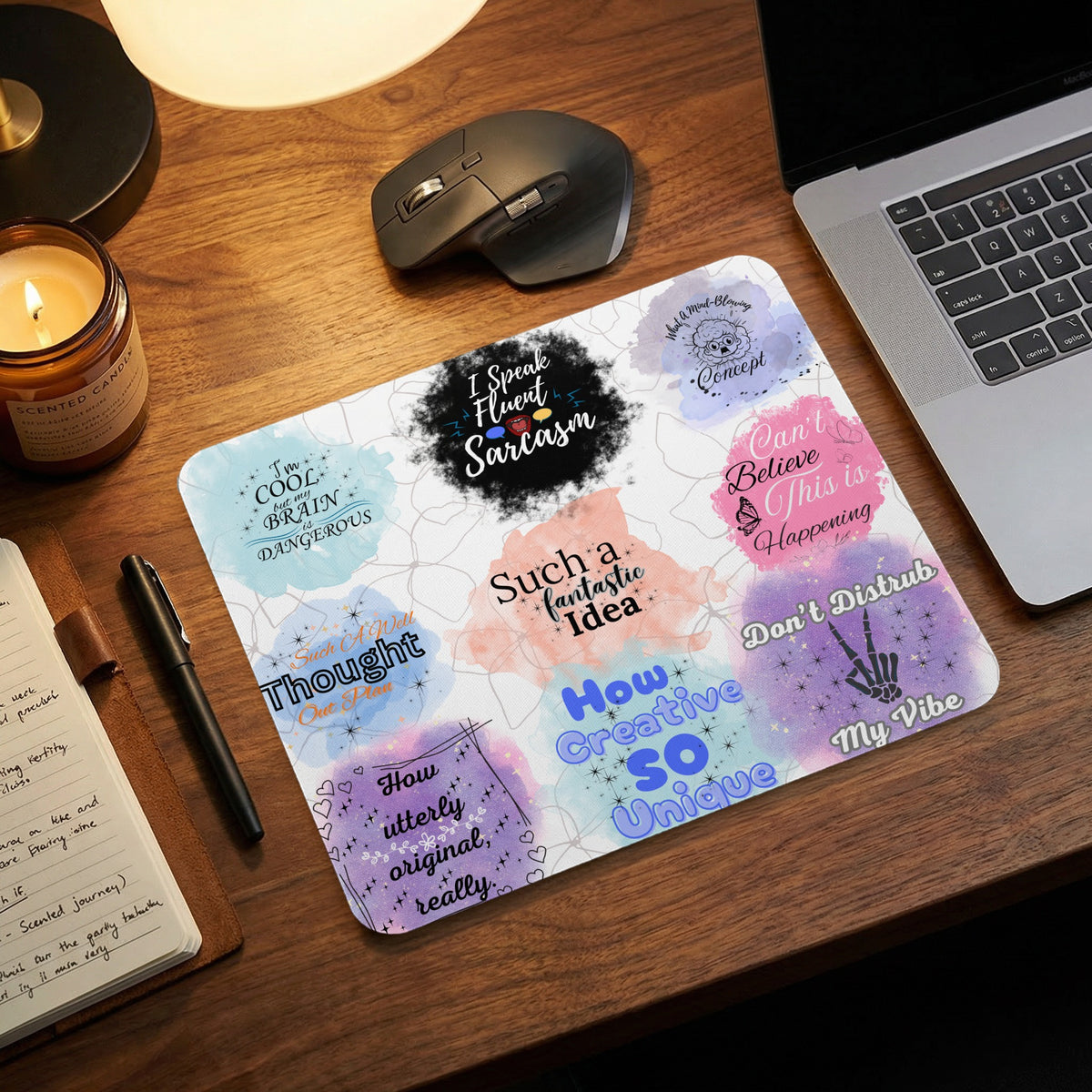 A rectangular desk mat printed with various sarcastic motivational quotes and colorful watercolor backgrounds.