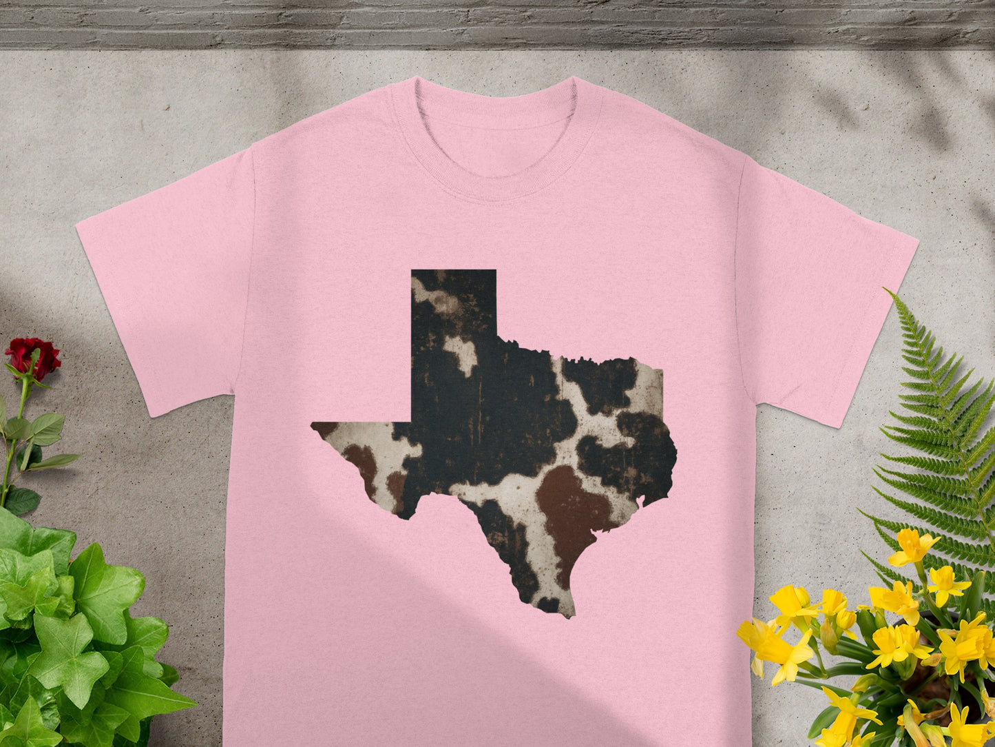 Pink t-shirt with a cowhide texture Texas outline graphic.