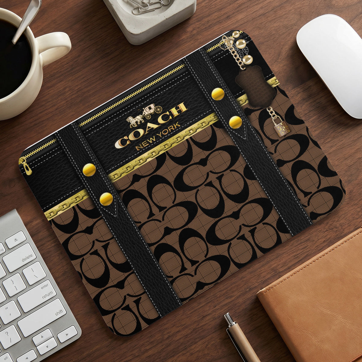 Coach New York monogram print tablet case with gold hardware and a lock charm.