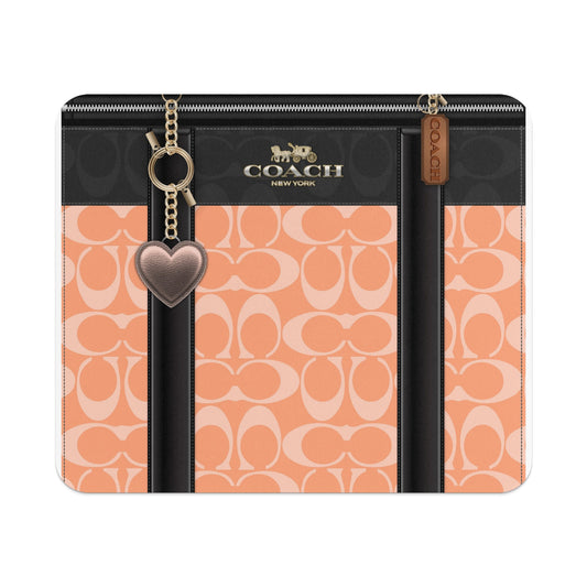 Coach monogram pattern with black trim, heart charm, and logo.