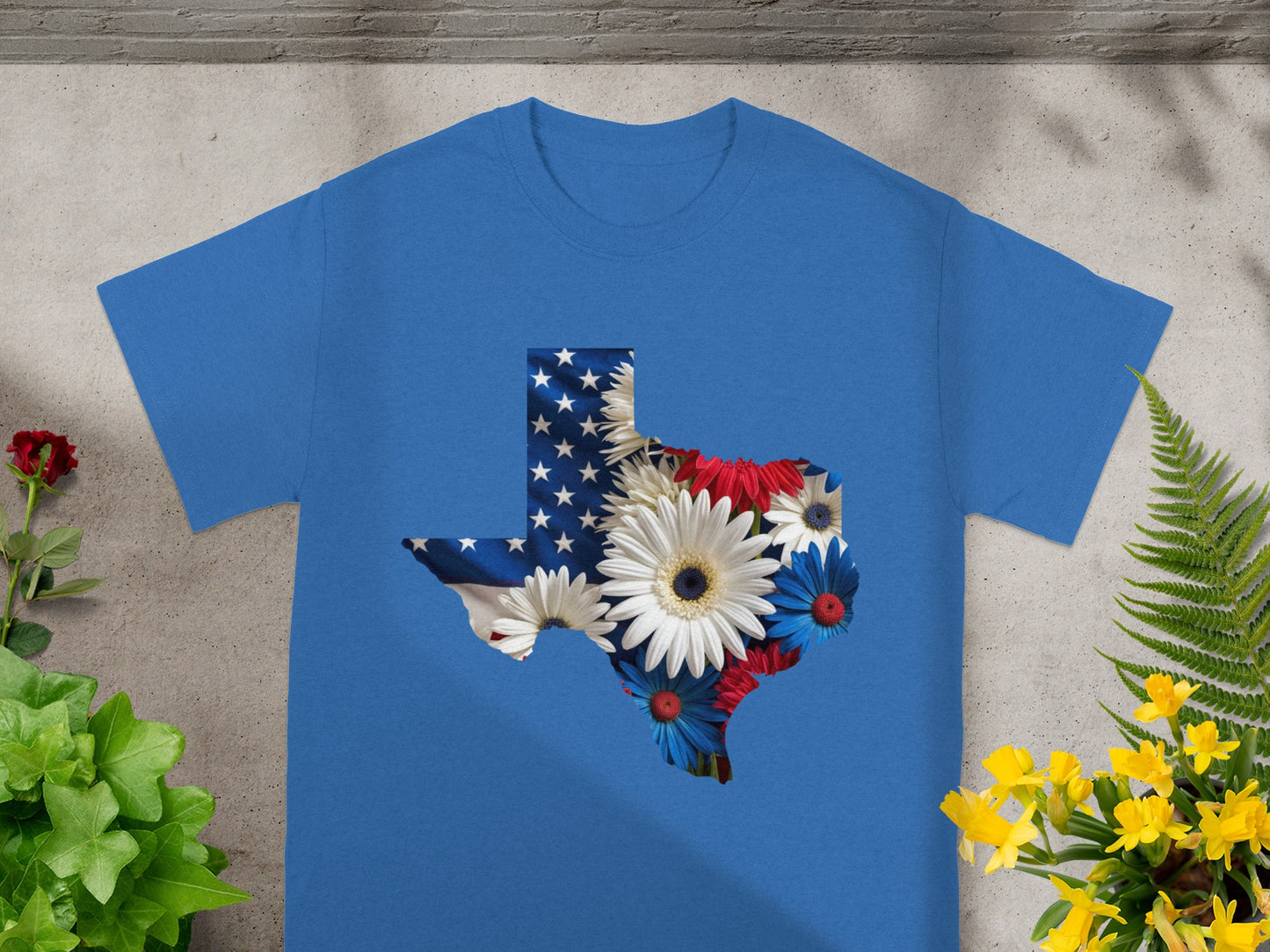 Texas shape on blue shirt filled with American flag and patriotic flowers.