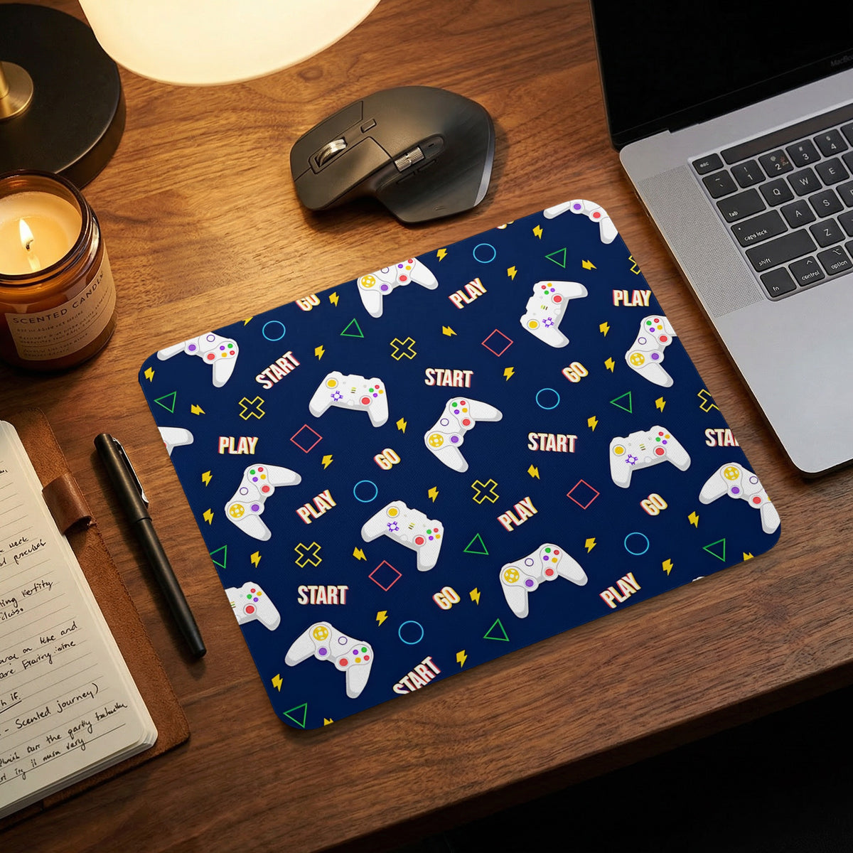 A blue mouse pad featuring a repeating pattern of white game controllers and words on a wooden desk.