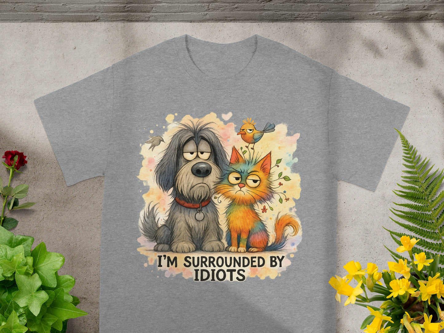 Grey t-shirt with cartoon dog, cat, and bird illustration reading "I'M SURROUNDED BY IDIOTS".