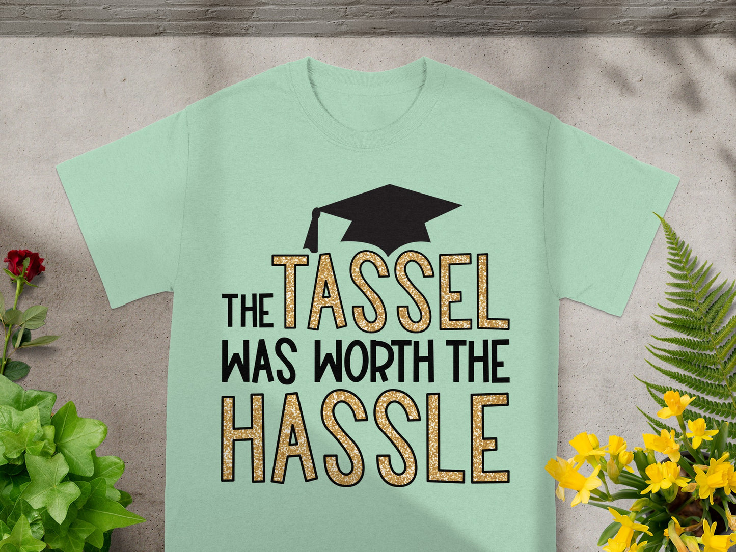 Light green t-shirt with graduation cap and "The tassel was worth the hassle" text.