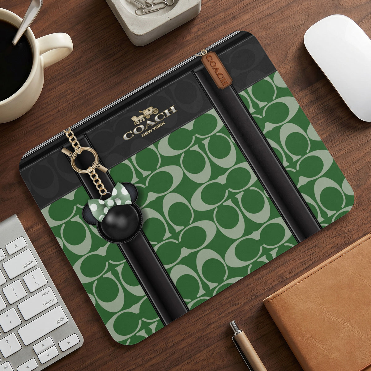 Coach green monogram pouch with a Mickey Mouse charm and gold chain.