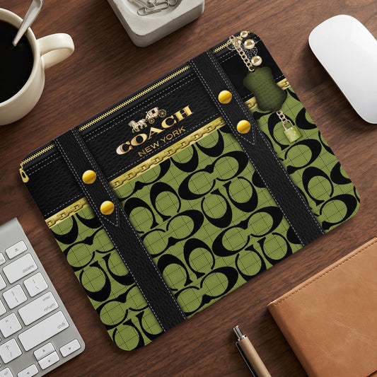 Coach New York logo mousepad with green signature pattern and gold chain detail.