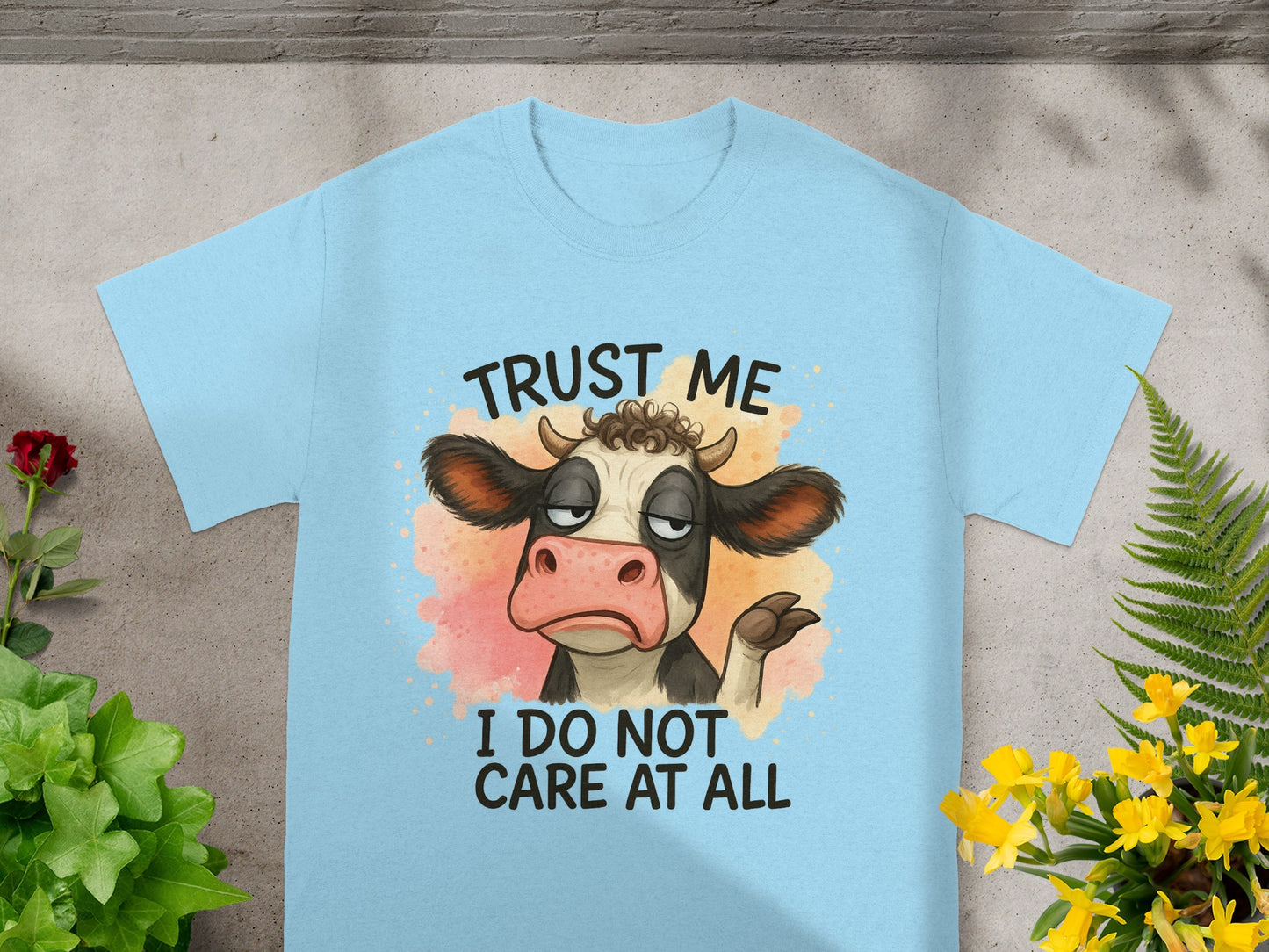 Light blue t-shirt with cartoon cow saying "Trust me, I do not care at all."