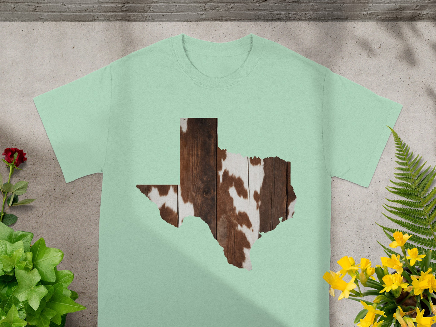 Light green t-shirt with a Texas outline filled with wood and cowhide texture.