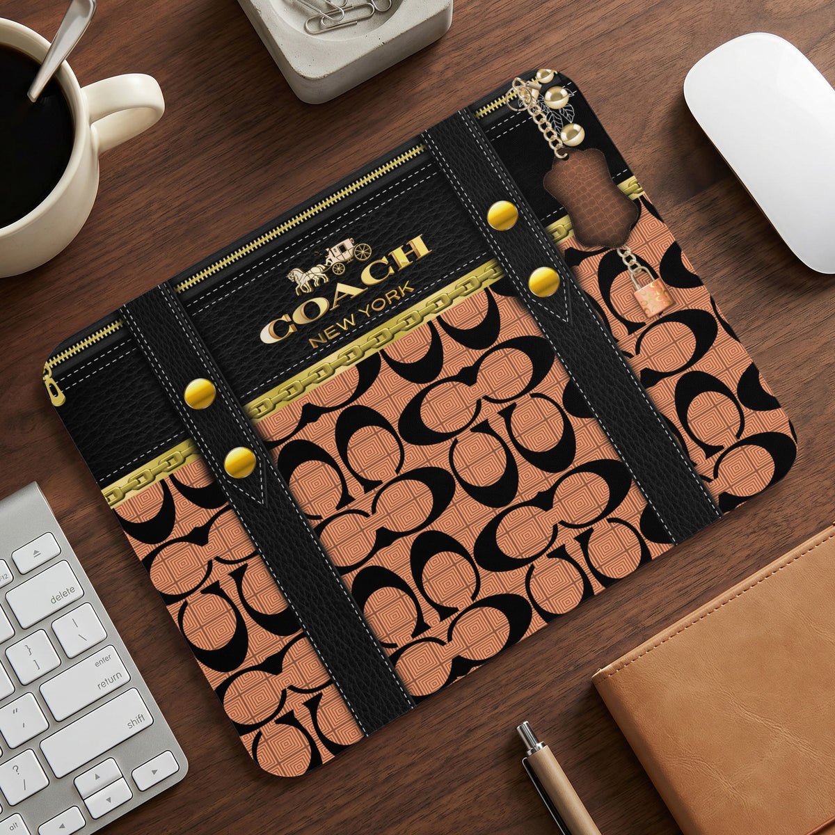 Coach New York logo and pattern on a black and tan mousepad with gold accents.