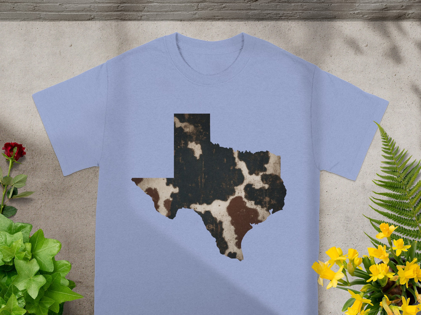 Light blue t-shirt featuring a distressed cowhide patternTexas map graphic.
