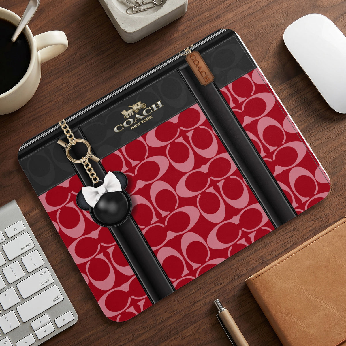 Coach laptop sleeve with signature print, black accents, and mouse charm.