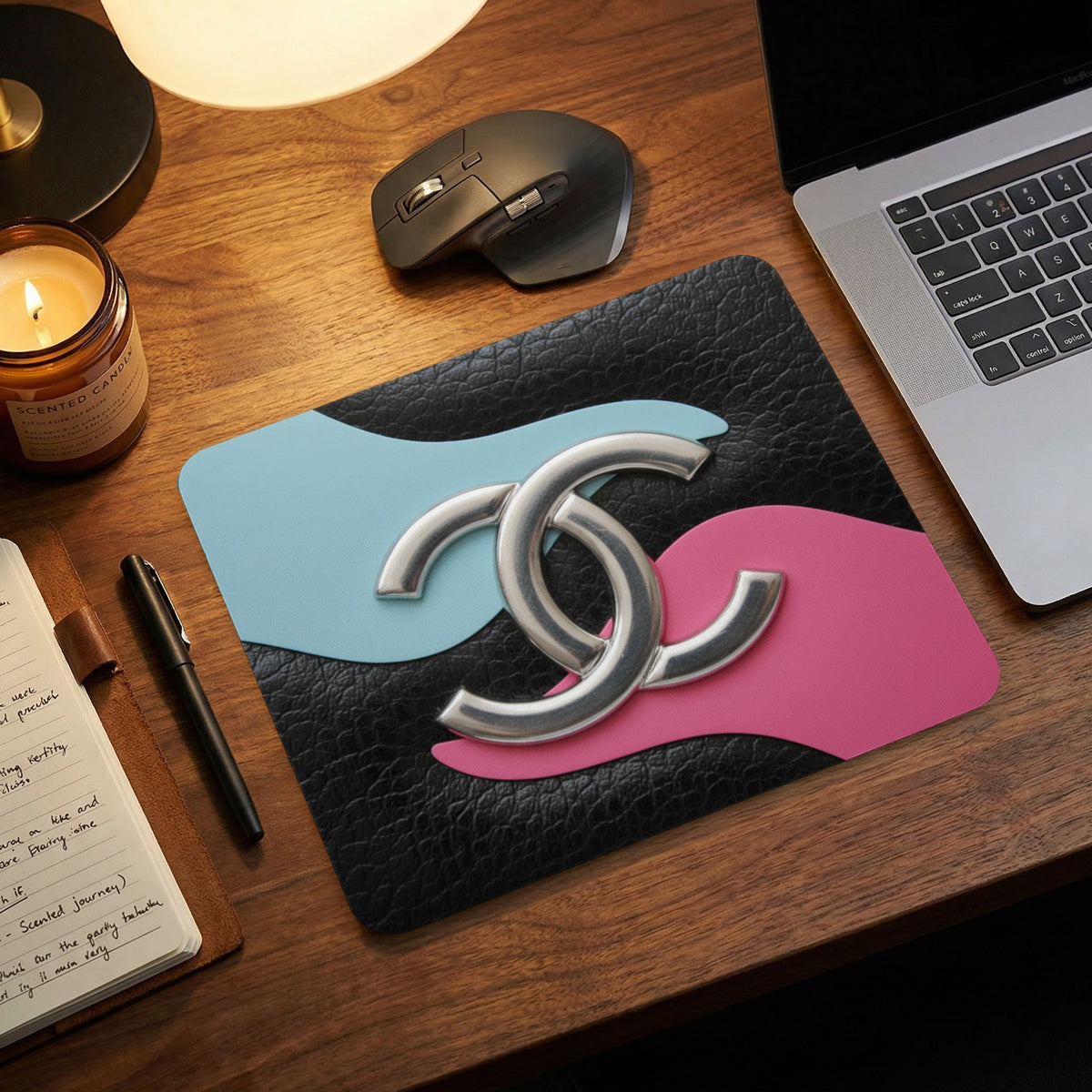 Black textured mousepad with interlocking silver logo and pink and blue accents.