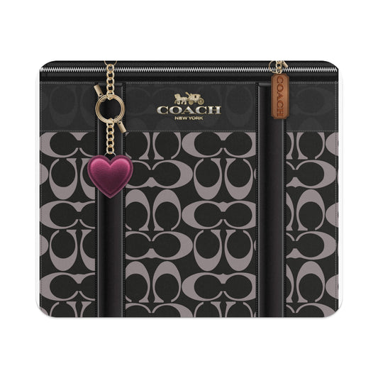 Black and grey Coach monogrammed wallet with heart and logo charms.