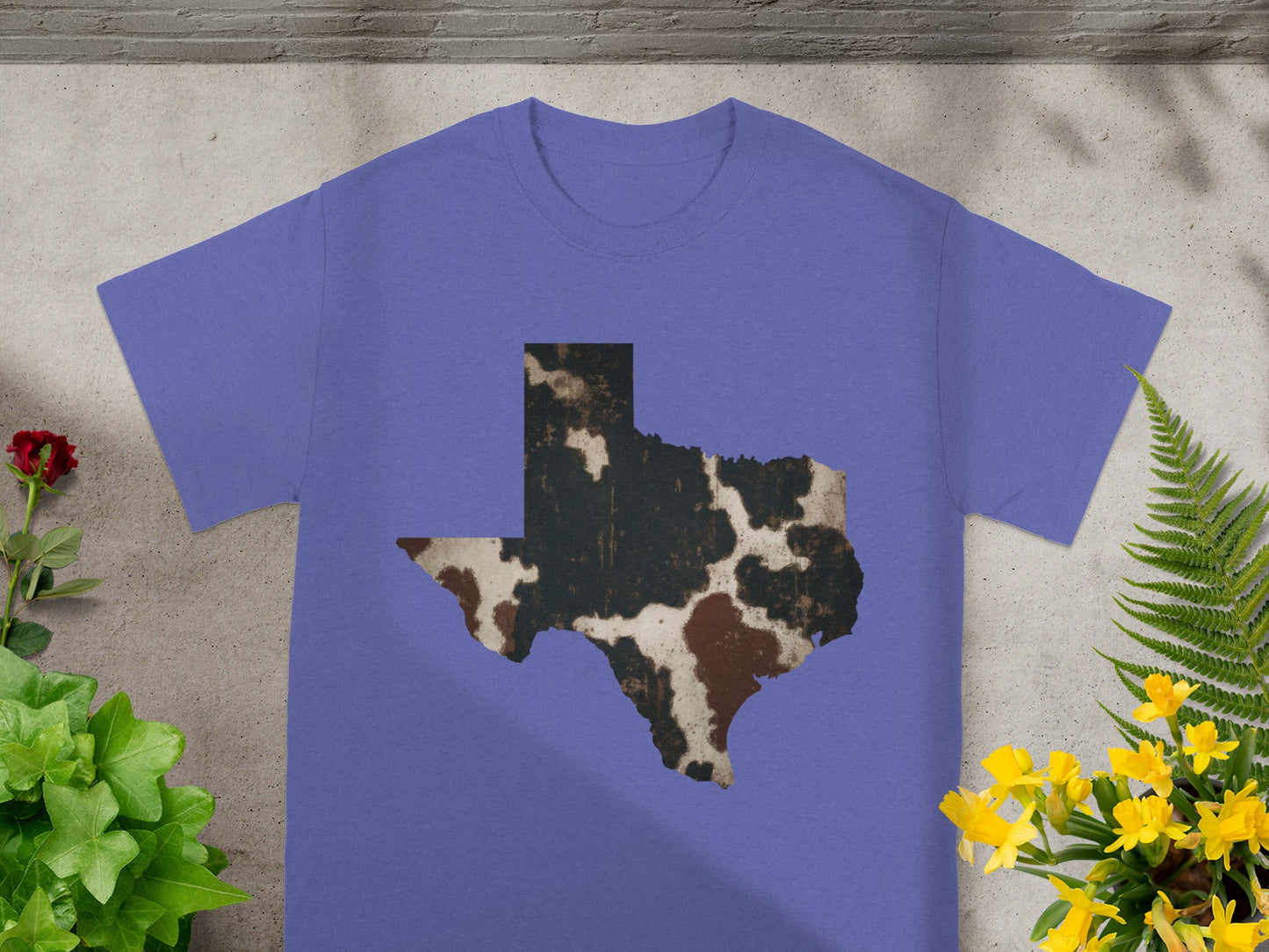 Purple t-shirt with distressed cow print Texas outline graphic.