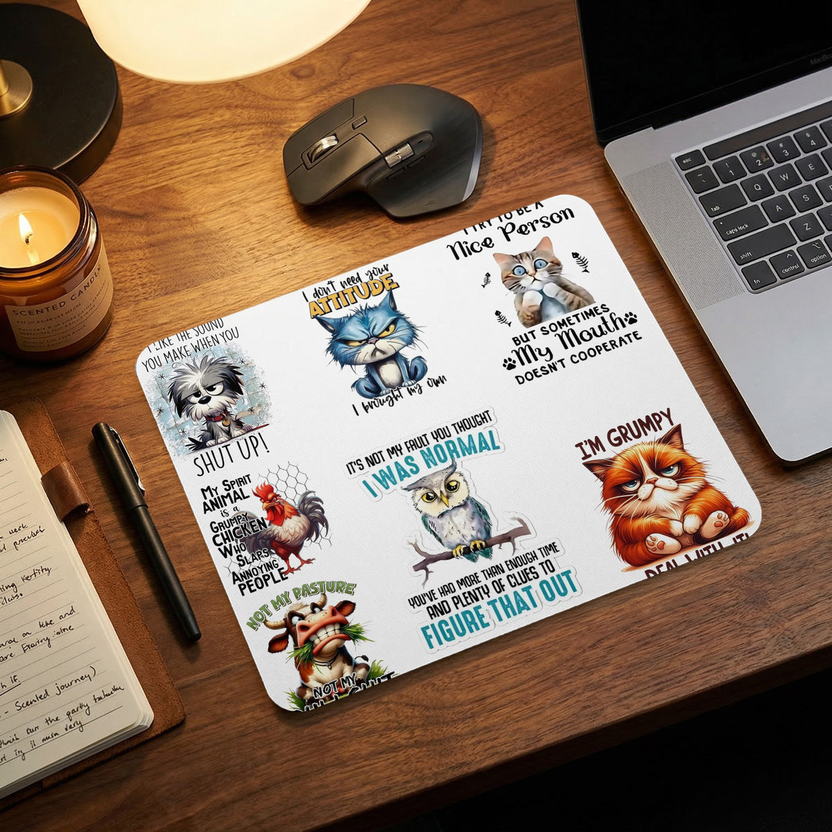 A white mouse pad with humorous illustrations of animals and text rests on a wooden desk.