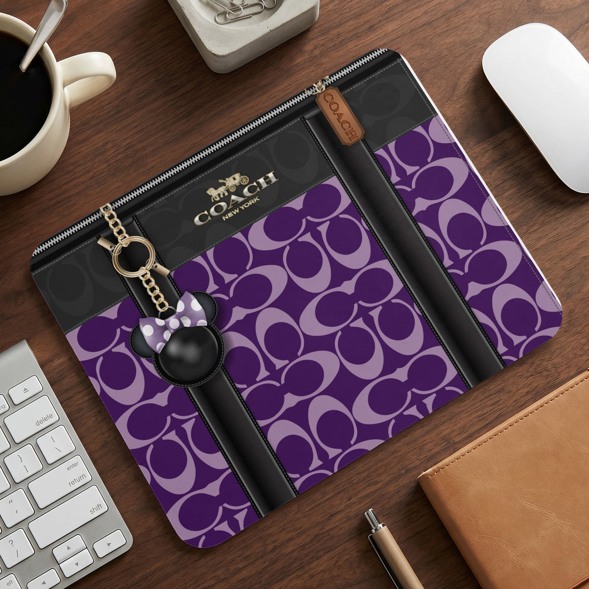 Coach laptop sleeve with purple monogram pattern and Minnie Mouse charm.