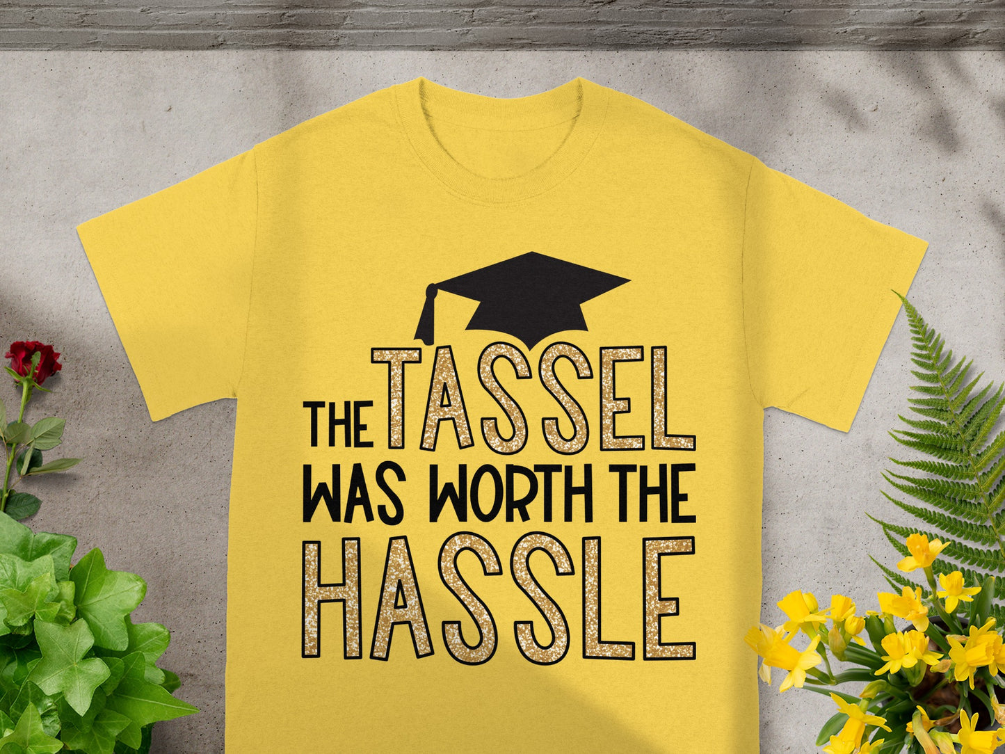 Yellow t-shirt with graduation cap graphic and "The Tassel Was Worth The Hassle" text.