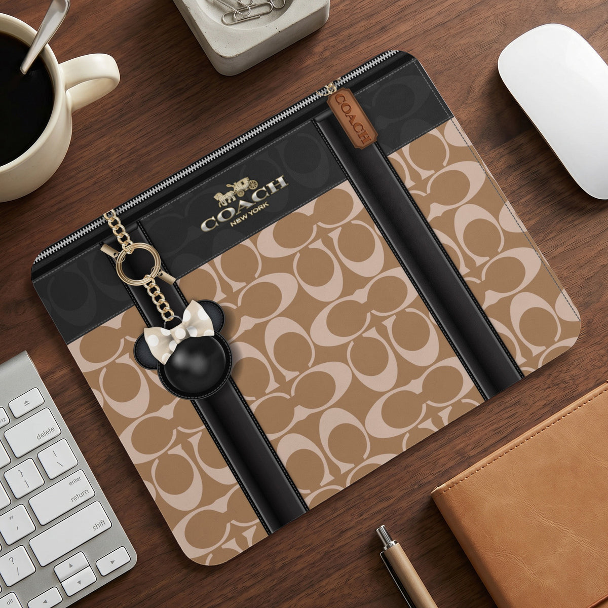 Coach signature pattern tablet sleeve with Mickey Mouse charm and gold accents.