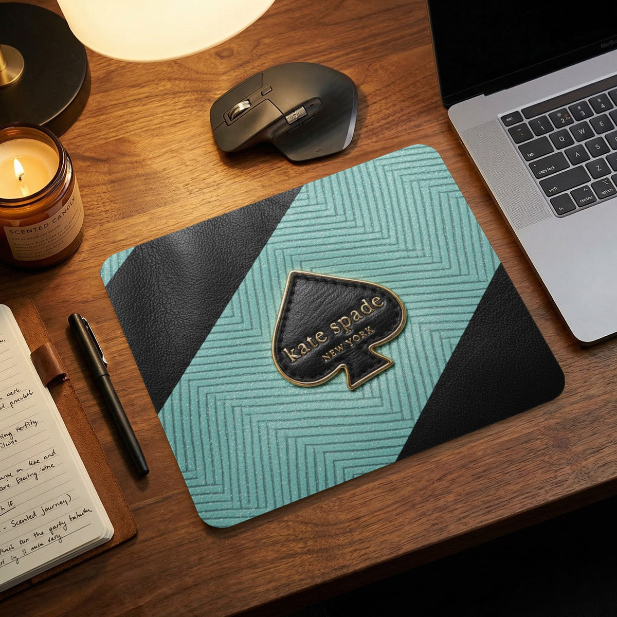 Kate Spade New York logo on a teal geometric mousepad with black trim.
