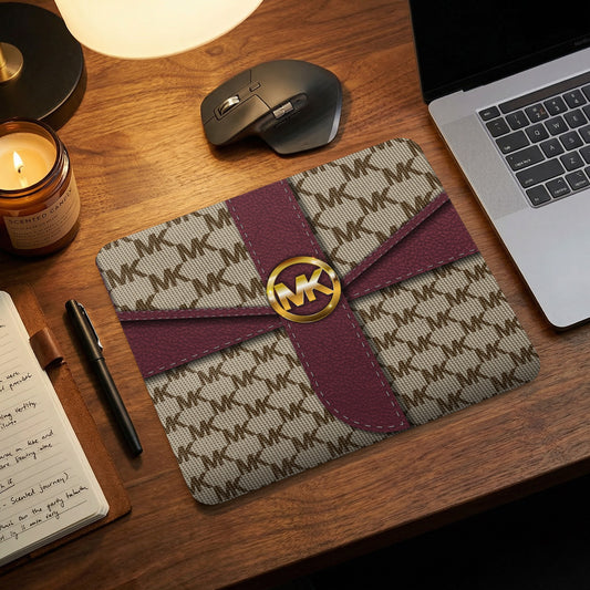 Michael Kors monogram mousepad with maroon ribbon and gold logo detail.