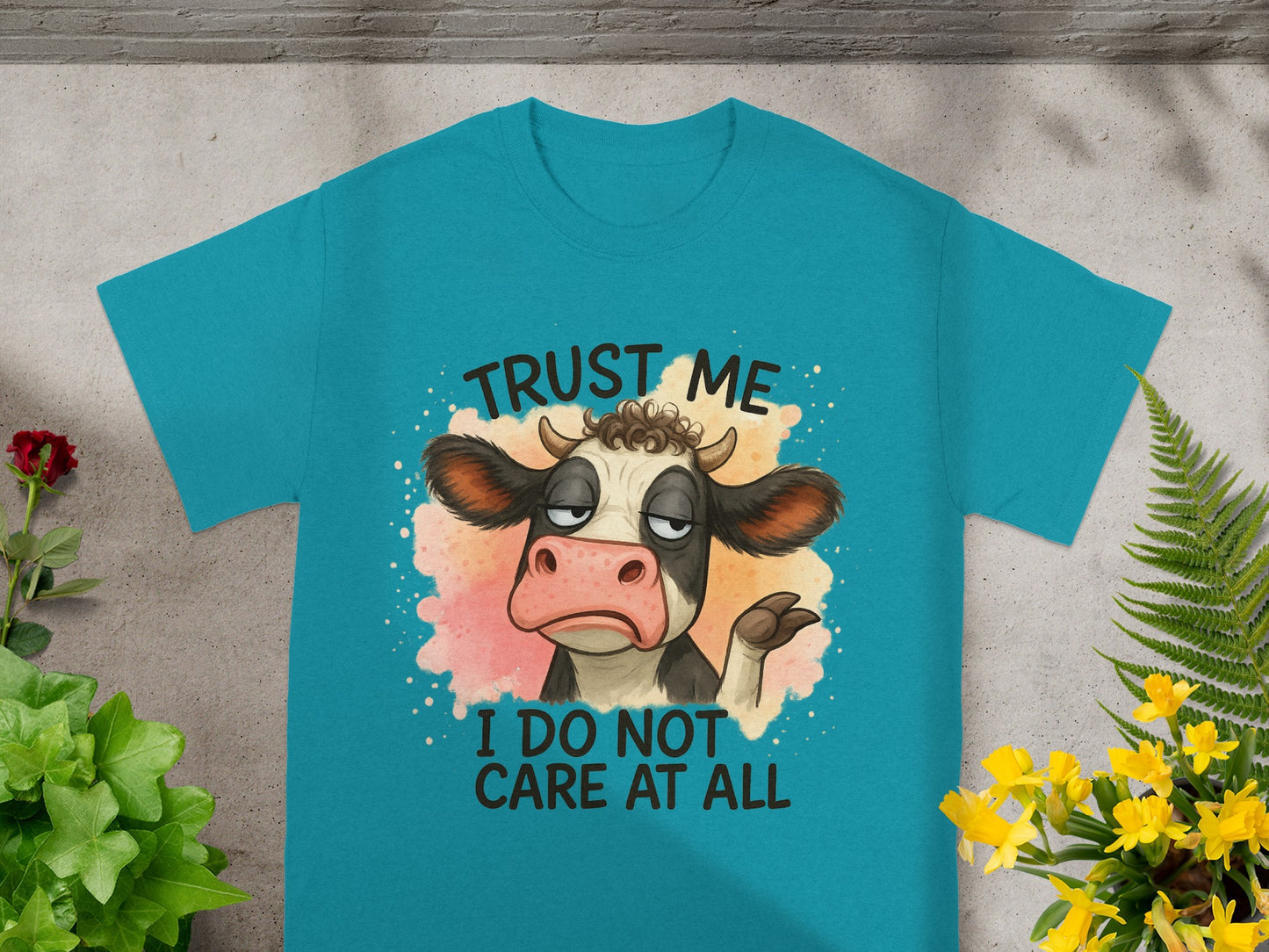Teal t-shirt with a cartoon cow saying "Trust me I do not care at all".