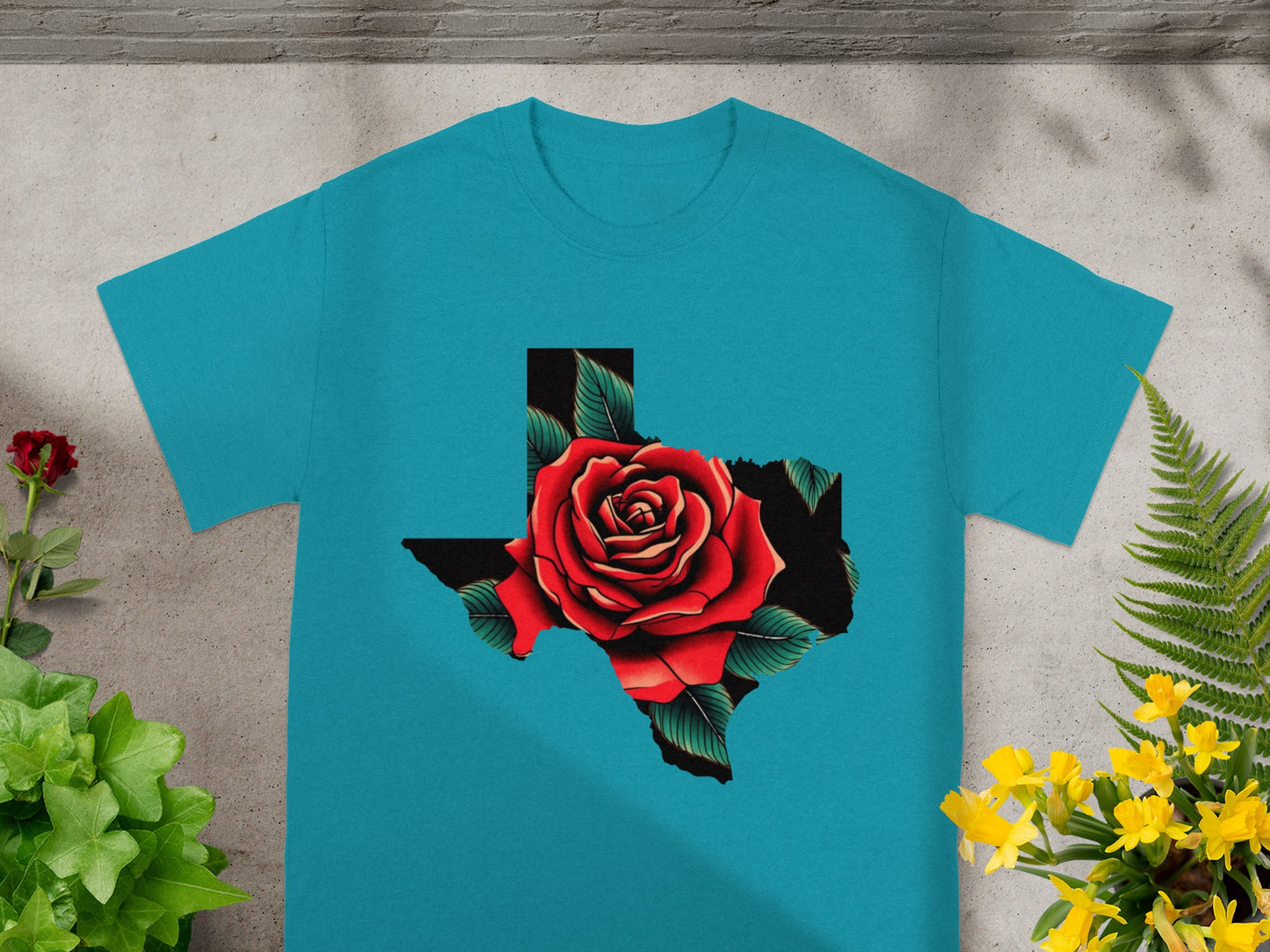 Teal t-shirt featuring Texas outline filled with a red rose and green leaves.