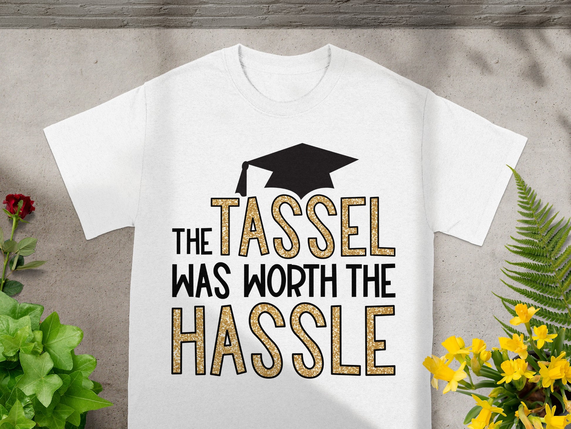 White t-shirt with "The Tassel Was Worth The Hassle" text and graduation cap graphic.