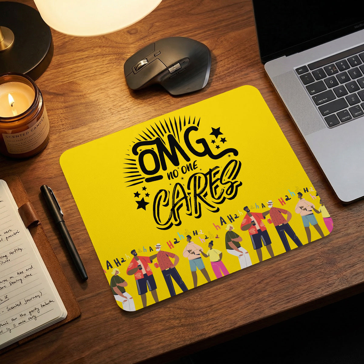 Bright yellow mouse pad with the black text "OMG no one cares" on a wooden desk with laptop and mouse.