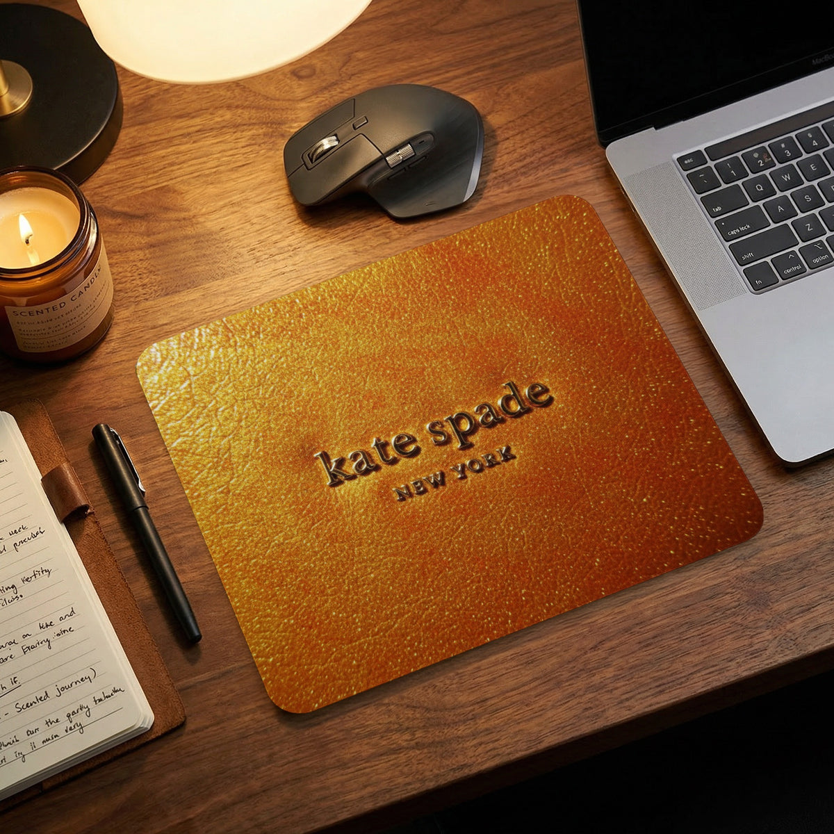 Kate Spade New York embossed gold mousepad on a wooden desk.