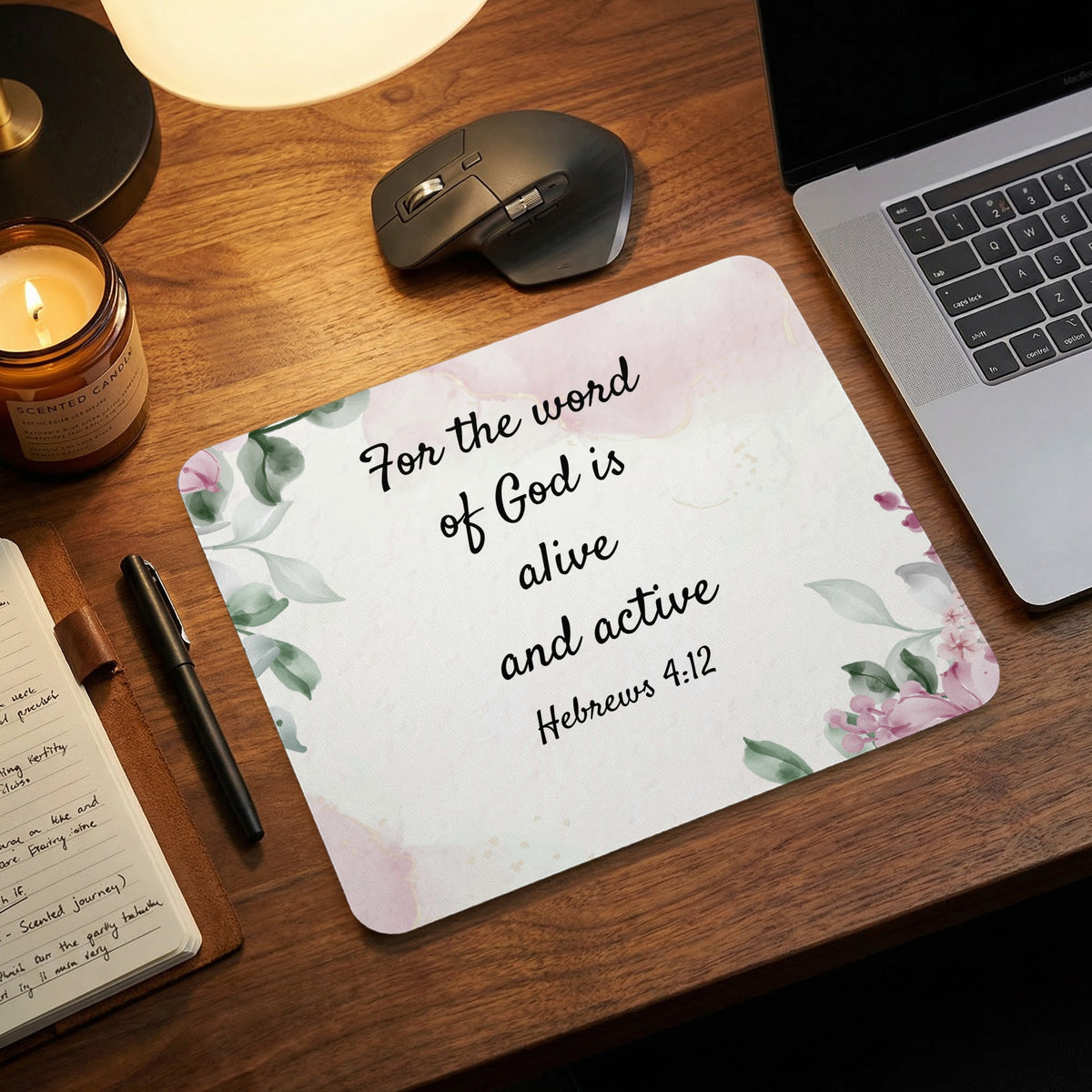 Mousepad featuring pink watercolor florals and the Bible verse Hebrews 4:12 on a wooden desk.